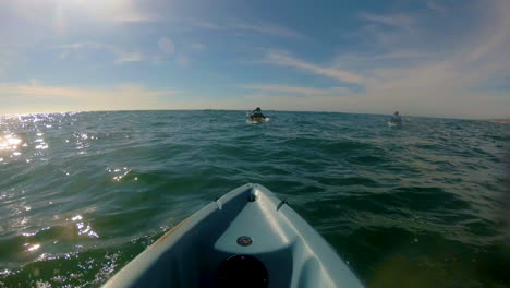 kayakers rowing towards the sea with the sun facing them at san diego