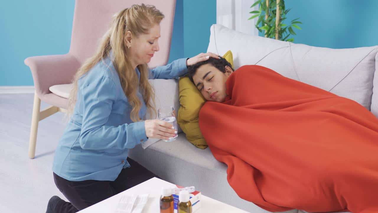 мать сожалеет о своем больном сыне, дает ему лекарство, чтобы восстановить здоровье.