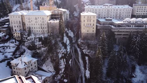 Drohnenaufnahme,-Die-Einen-Großen-Wasserfall-Mitten-In-Einer-Alten-Stadt-In-Den-Bergen-Zeigt