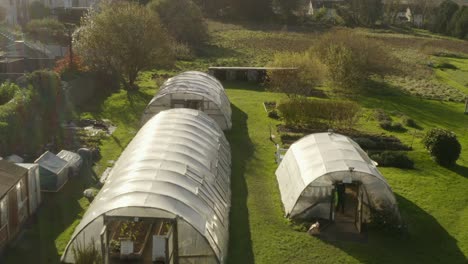 aerial flying over greenhouses on a community garden field