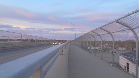 los coches conducen sobre un puente en el anochecer