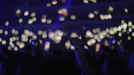 Multitud-De-Fanáticos-De-La-Música-Con-Luces-En-Una-Sala-De-Conciertos-Oscura