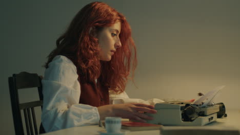 young woman is writing on typewriter