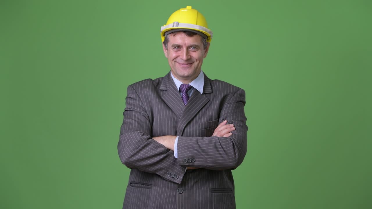 hombre de negocios maduro y guapo contra un fondo verde