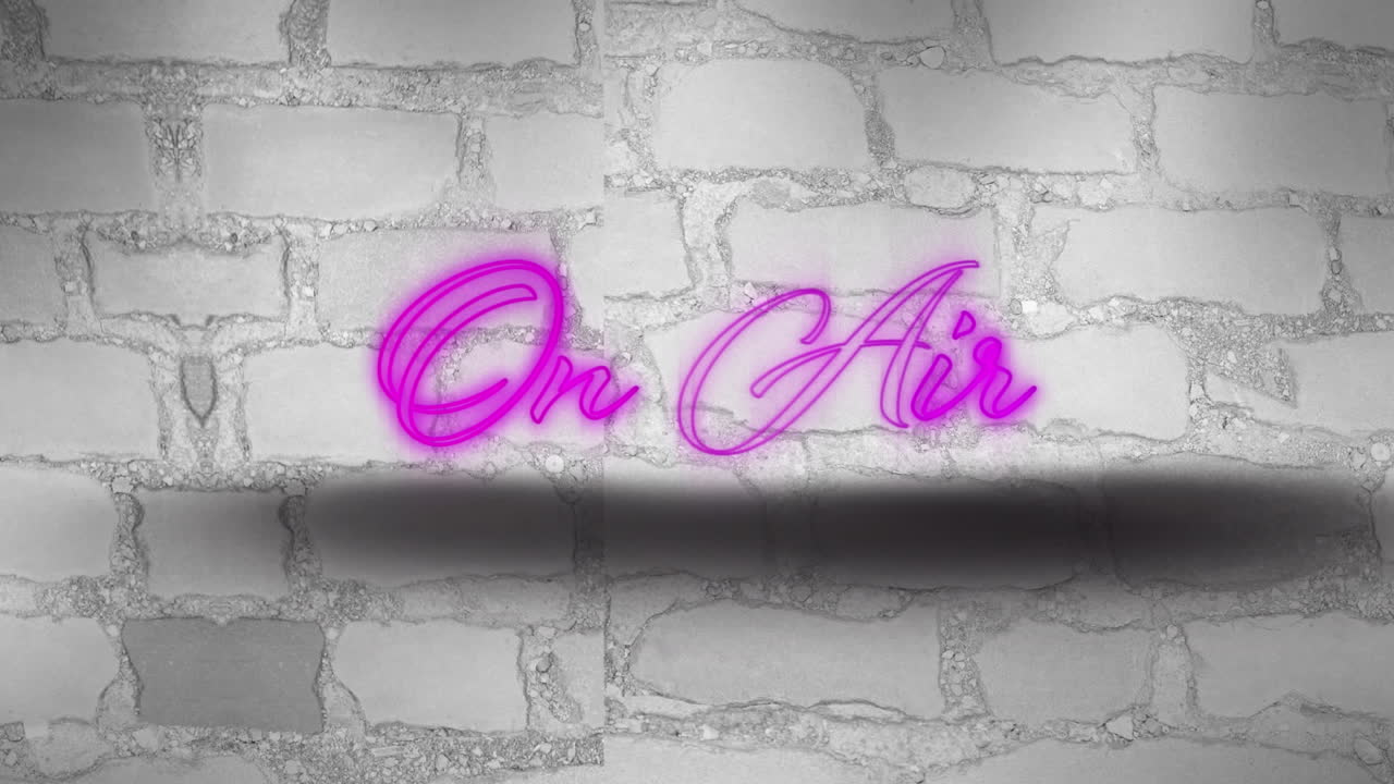 texto de neón púrpura en el aire contra una pared de ladrillo gris en el fondo