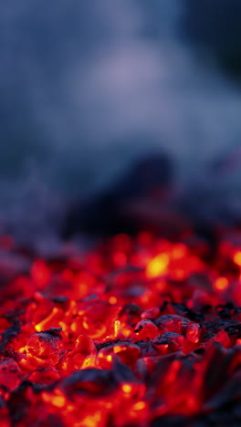 embers of burnt-out fire. red and black charcoals in smoke. background of bright coals after burning fire in the evening. vertical video