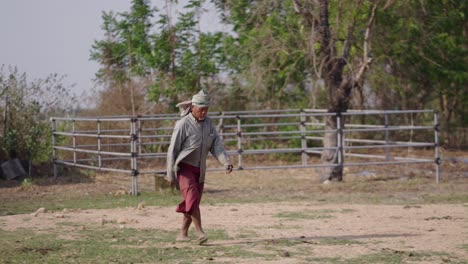elderly man walking through a rural landscape