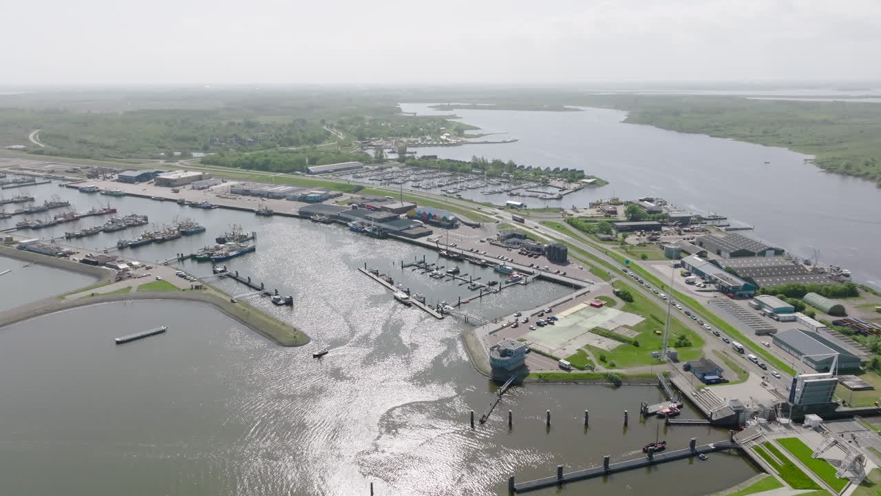 Aerial view view of the harbour at Lauwersoog in the Netherlands. The video shows the coastal infrastructure, docked boats, ferry routes and the surrounding green landscape leading into the North Sea