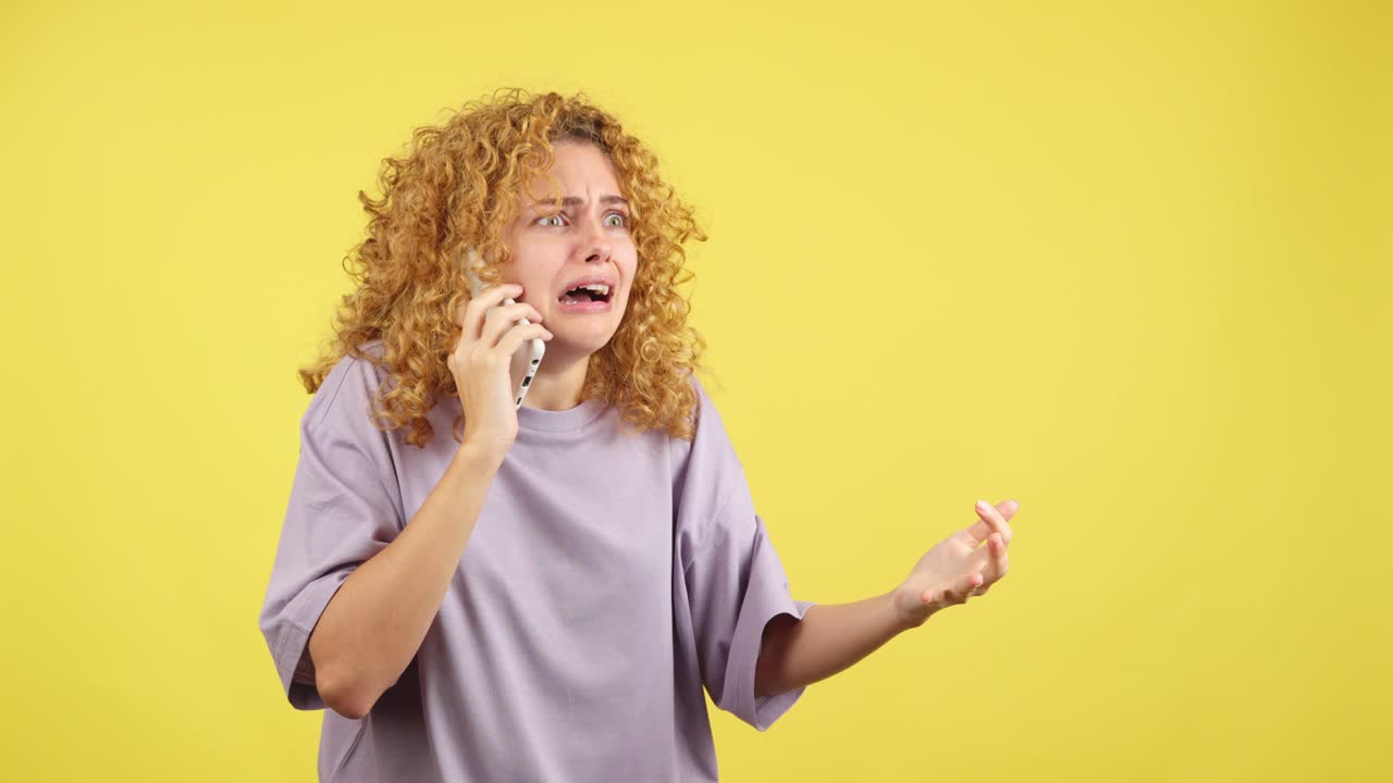 Donna angosciata che reagisce a una telefonata con vari gesti delle mani su sfondo giallo.