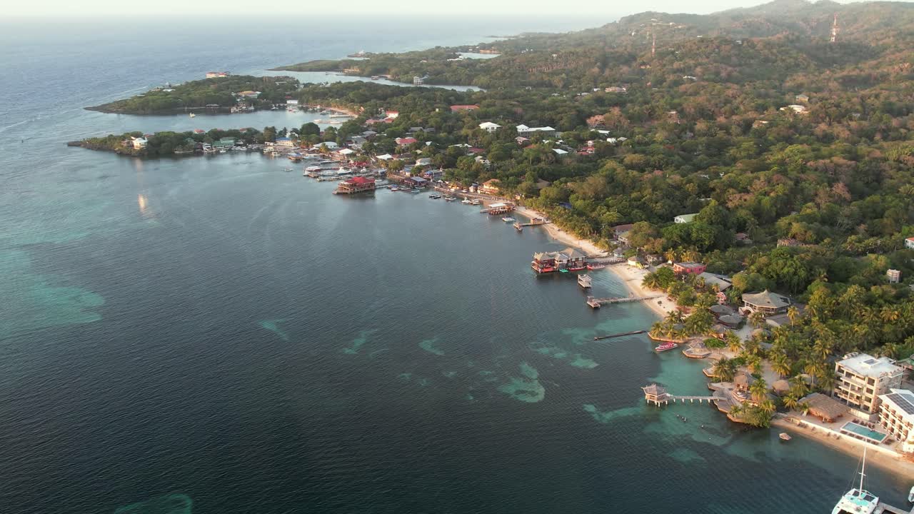 Vista aerea della costa, barche, palme verdi, resort, sulla spiaggia sabbiosa al tramonto.