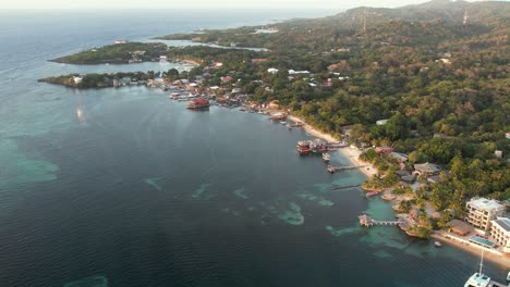 aerial view of the coast, boats, green palms, resorts, on the sandy beach at sunset