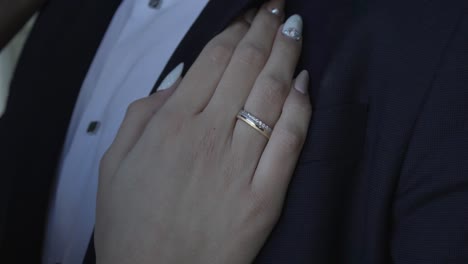 anillo en la mano de la novia, descansando sobre el pecho del novio