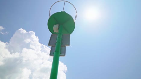 Stunning-HD-footage-of-a-green-lighthouse-in-Koper's-marina,-illuminated-by-the-sun