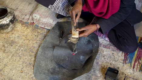 slow shot of tuareg man cutting in wood in traditional way in algeria