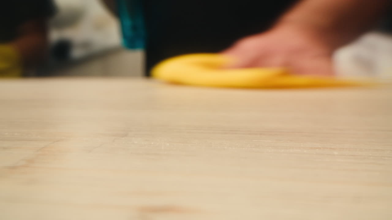 Spruzzare e pulire a mano una superficie in legno con una soluzione detergente