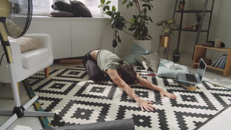 young sportive woman practicing yoga at home