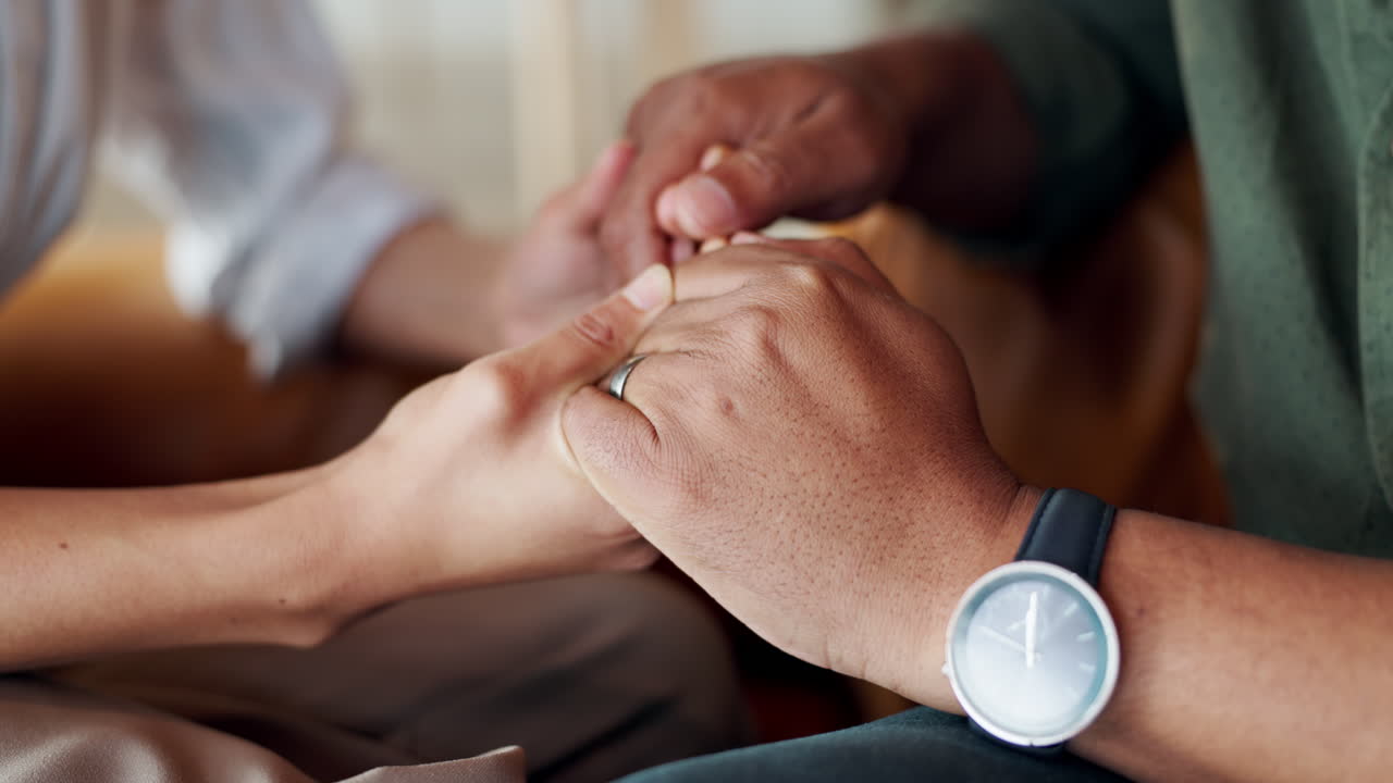 A couple holding hands in a supportive and loving manner