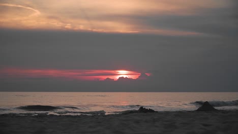 there is red sunset on the beach, small tides in the sea