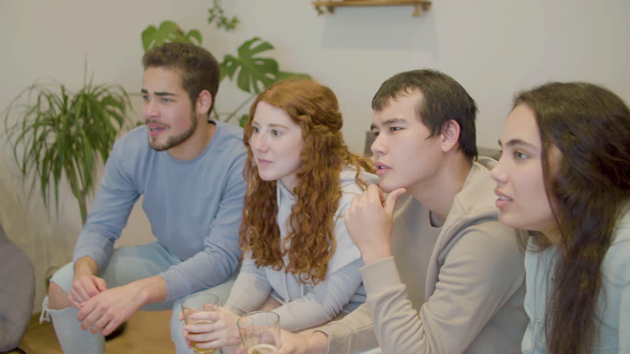 스포츠 팬 들 이 거실 에서 tv 에서 축구 경기 를 보고 있다