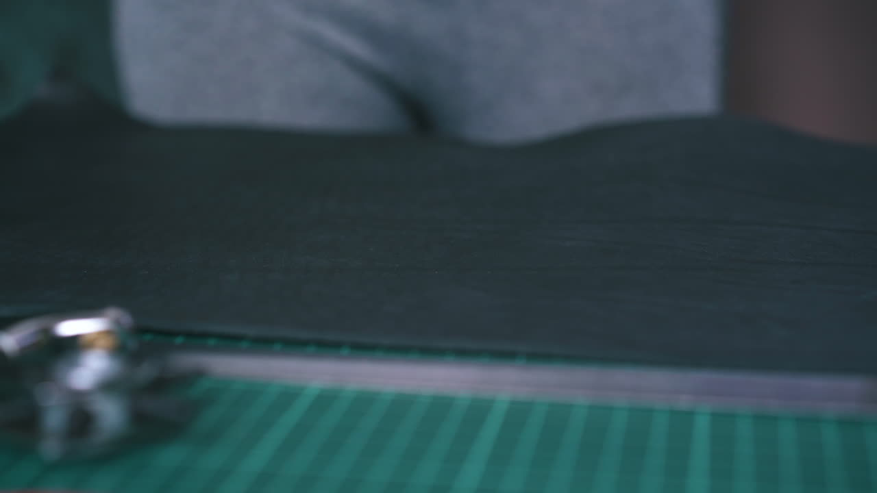 el diseñador pone tela de cuero negro en un tablero de cojín especial