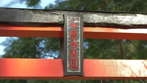 puerta roja con letras escritas en japonés en un jardín japonés budismo zen pacífico