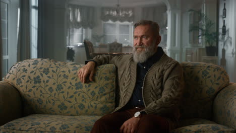 handsome old man sitting on the couch in luxury house