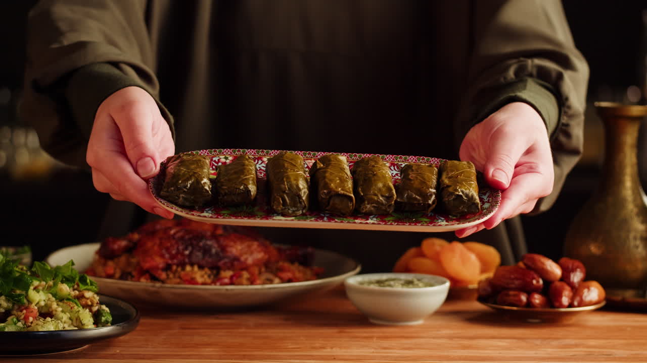 Hands holding a plate of dolma