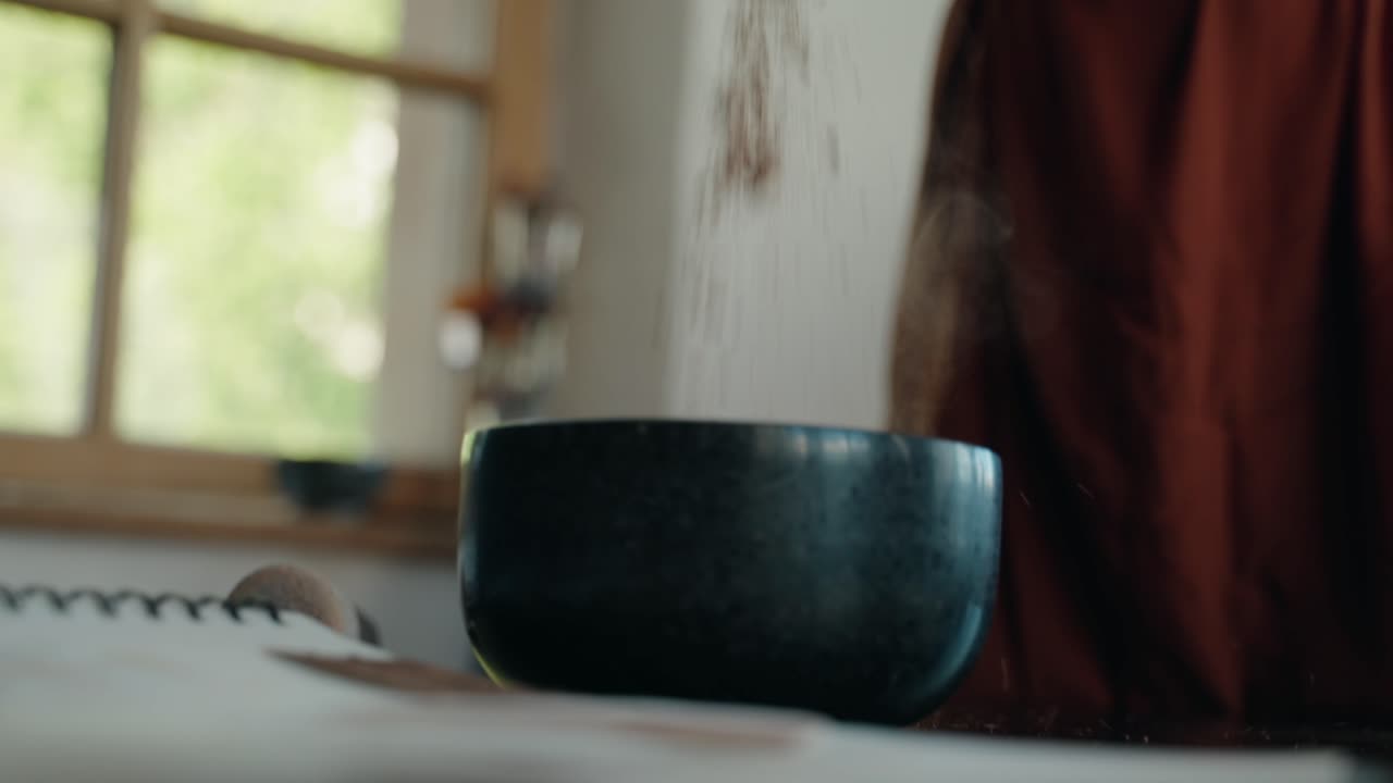 suelo de arena roja que cae de la mano al mortero, vista de cerca