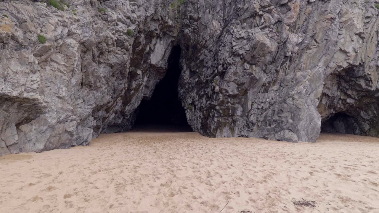 아일랜드 도네갈에 있는 해변 섬에 있는 동굴의 그림 같은 암석 - 틸트 다운 샷