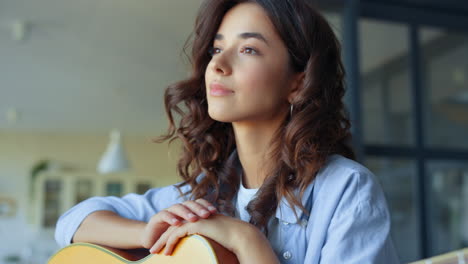 caucasian woman holding acoustic guitar