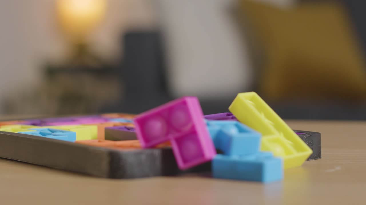 rompecabezas de formas entrelazadas de colores en la mesa en casa para niños diagnosticados con tea 9