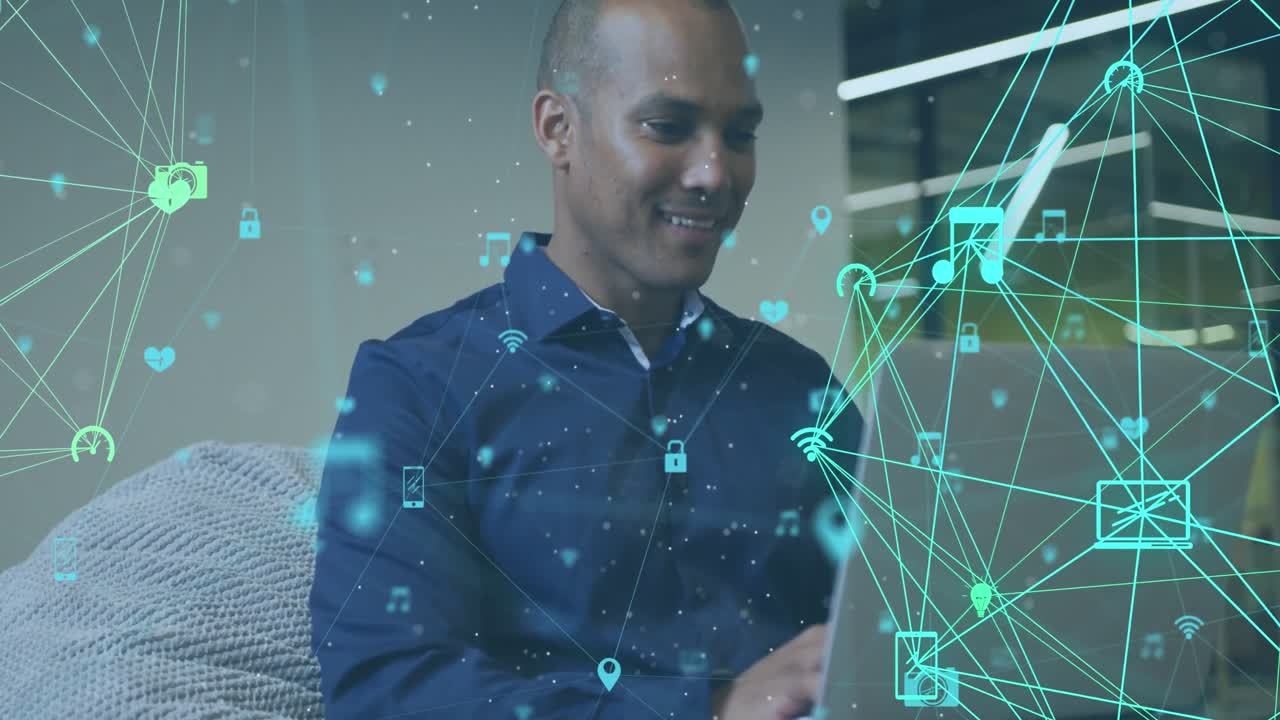 Animation of two globes of digital icons spinning against biracial man using laptop at office