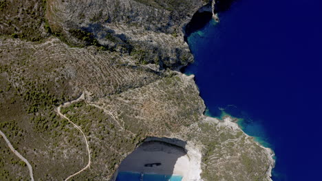 Aerial:-Top-down-backwards-reveal-shot-of-Navagio-beach-in-Zakynthos,-Greece