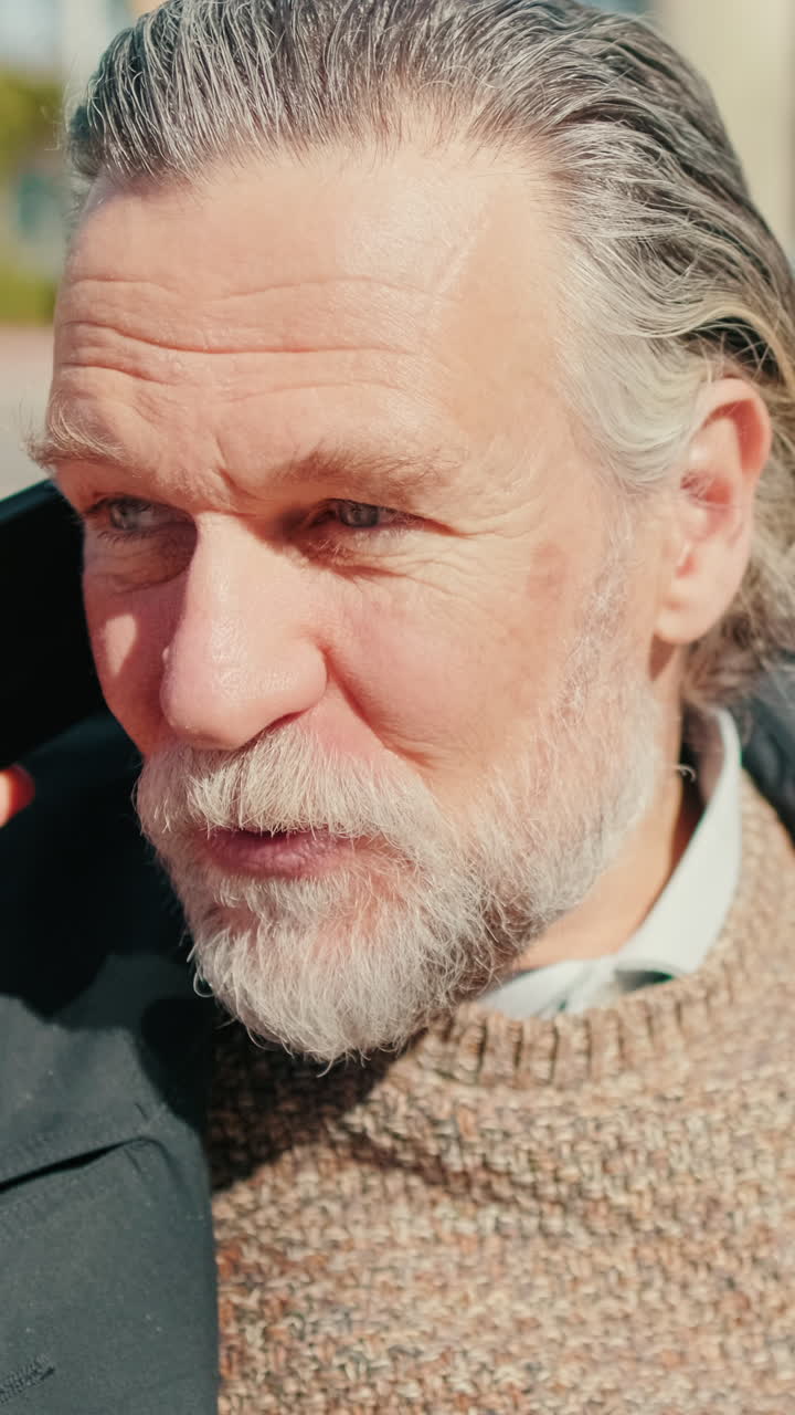 Mature Man Talking On Phone In City