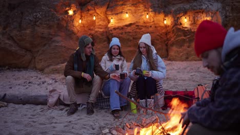 friends enjoying a nighttime campfire on the beach