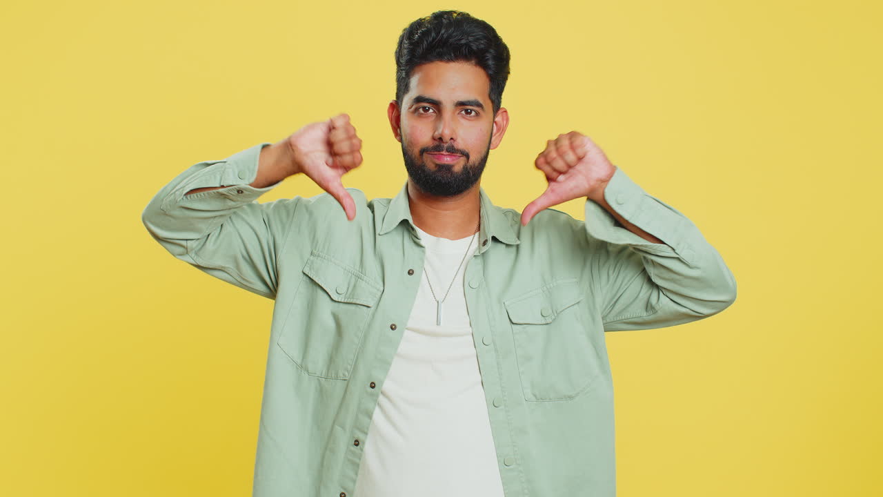 Upset man guy showing thumbs down gesture disapproval dissatisfied dislike negative feedback