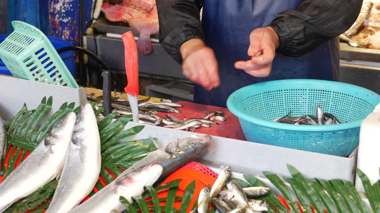 pescador limpiando y vendiendo pescado en un mercado