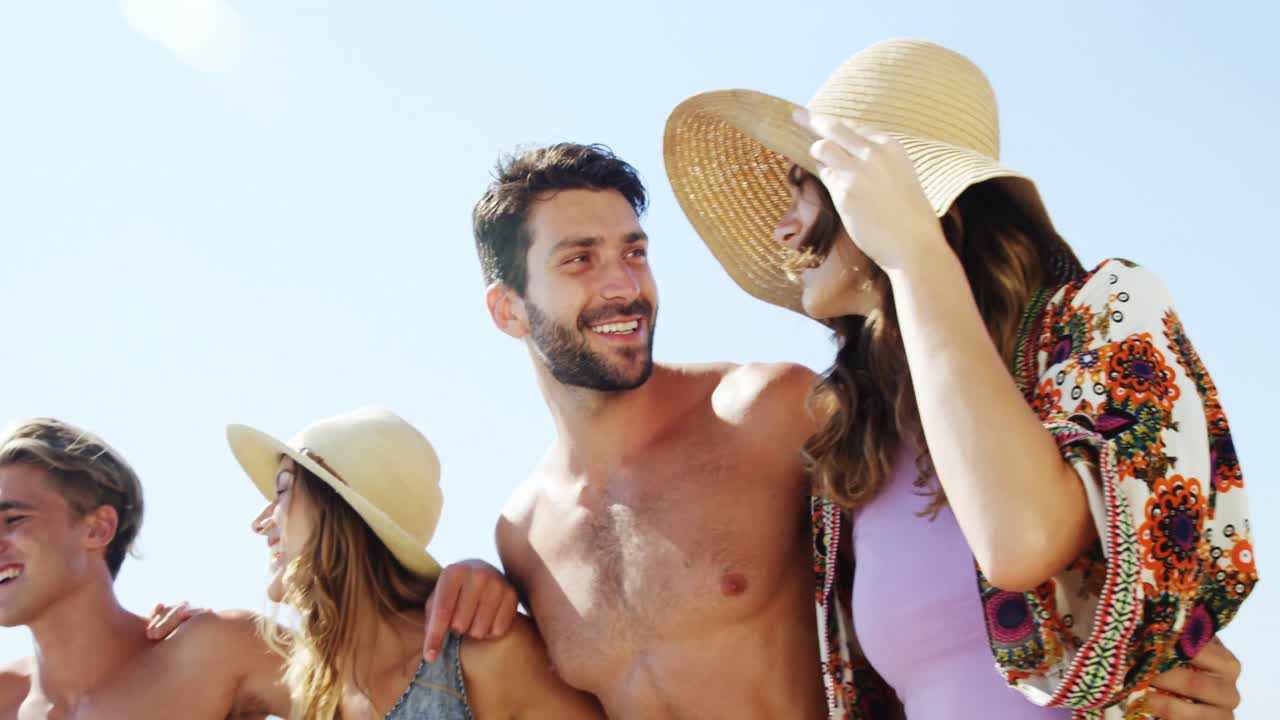 amigos felices caminando juntos en la playa