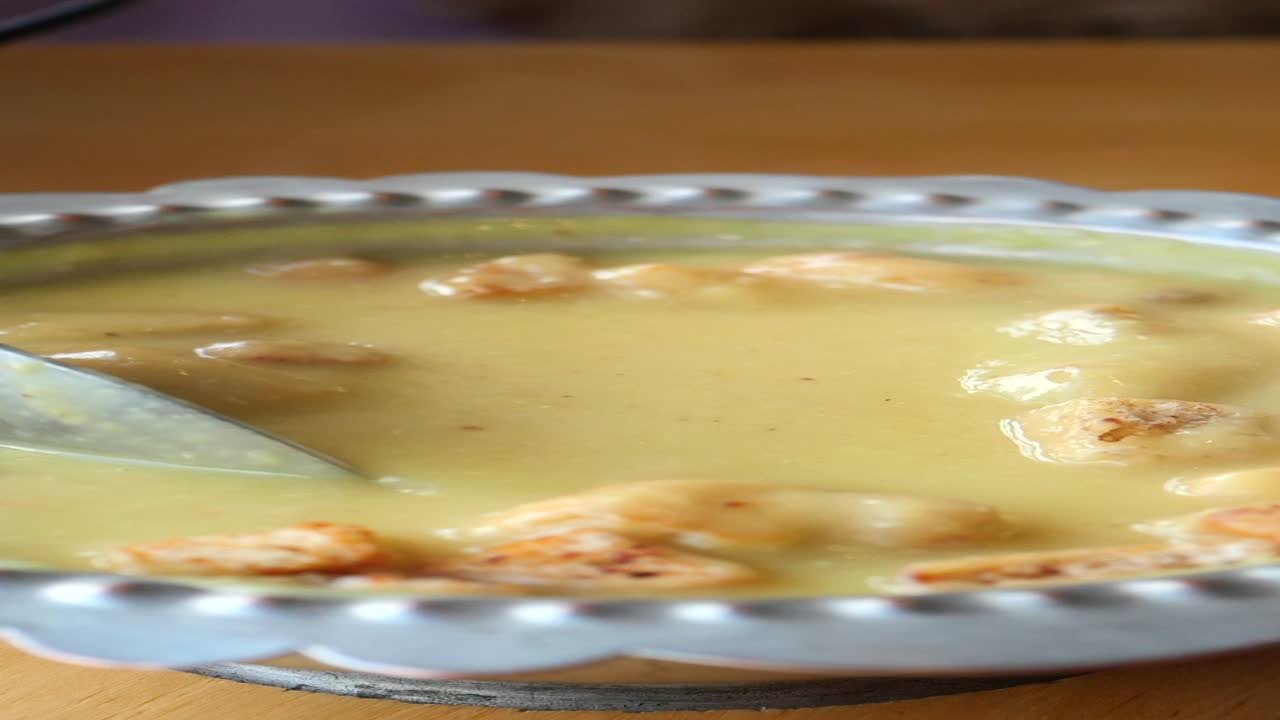 primer plano de un plato de sopa de lentejas con una cuchara