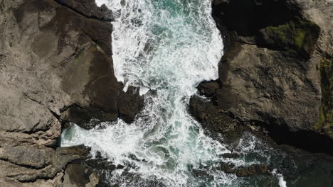 White-foamy-waves-relentlessly-flow-into-a-narrow-cove-and-break-against-rocks