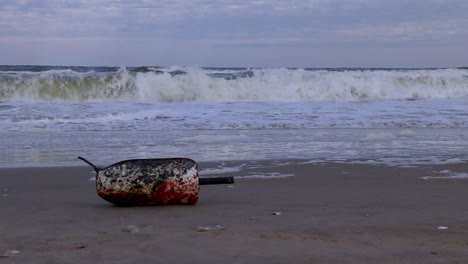 Close-up,-slow-motion-view-of-a-small-styrofoam-float-used-in-commercial-crab-fishing-washed-onto-the-shore