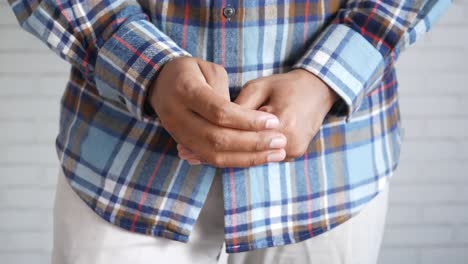 man with folded hands in plaid shirt