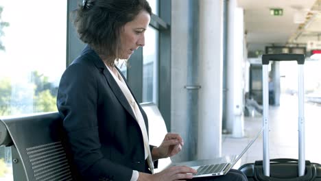 Mujer-De-Negocios,-Utilizar-La-Computadora-Portátil,-En,-Estación-De-Tren