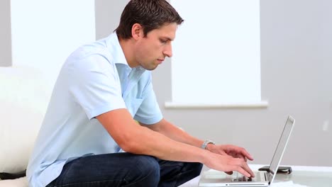 Content-man-using-his-notebook-sitting-on-couch