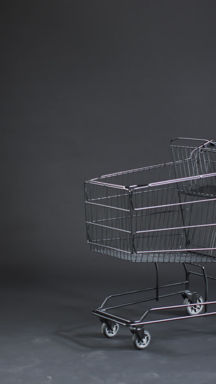 Vertical video of shopping trolley with copy space over grey background