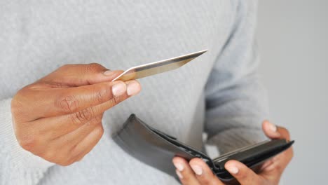 a man holds out a credit card in front of his wallet