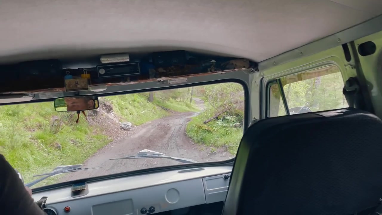 Point of view from inside a vehicle driving along a rough forest road toward Ak-Kem Valley in the Altai Mountains, Altai Republic, Russia, adventure travel concept