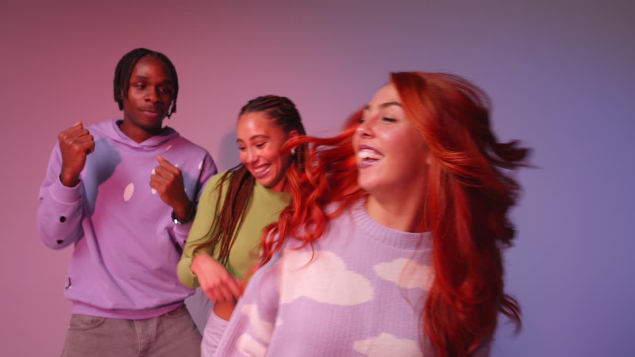 fotografía de estudio de jóvenes amigos de la generación z bailando en un club contra un fondo rosa 4