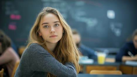 young college student sitting in classroom, looking away with hand on chin, appearing thoughtful and contemplative during a university lecture