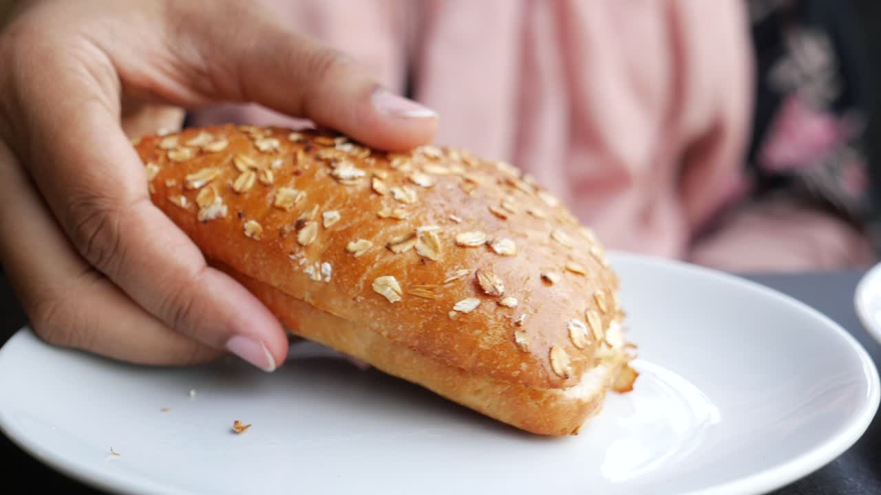persona que sostiene un sándwich de pan de avena tostado